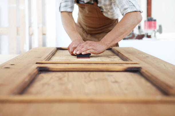 hombre lijando una puerta
